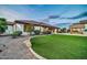 Professionally landscaped backyard featuring lush grass and barbecue area offers a serene outdoor retreat at 10059 W Villa Lindo Dr, Peoria, AZ 85383