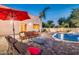 Cozy backyard patio with comfortable seating, and a view of the refreshing pool and lush landscaping at 10059 W Villa Lindo Dr, Peoria, AZ 85383