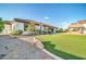 A well-maintained backyard features green grass, an outdoor kitchen, and a covered patio at 10059 W Villa Lindo Dr, Peoria, AZ 85383