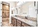 Bathroom featuring dual sinks, granite countertops, wood cabinets, and a bathtub at 10059 W Villa Lindo Dr, Peoria, AZ 85383