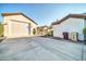 Spacious concrete driveway leading to a white garage and covered outdoor area, framed by a clear blue sky at 10059 W Villa Lindo Dr, Peoria, AZ 85383
