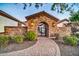 Charming stone archway entrance with a gate and brick-paved walkway leading to the property at 10059 W Villa Lindo Dr, Peoria, AZ 85383