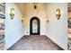 Covered entryway featuring sconce lighting and a decorative wrought iron door at 10059 W Villa Lindo Dr, Peoria, AZ 85383