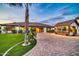 Expansive home exterior with a long driveway, well-maintained lawn, and outdoor kitchen area at 10059 W Villa Lindo Dr, Peoria, AZ 85383