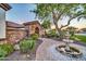 Landscaped front yard with stone archway, mature trees, and a serene fountain at 10059 W Villa Lindo Dr, Peoria, AZ 85383
