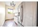 A laundry room with stainless steel refrigerator, cabinetry, and a view to the outside at 10059 W Villa Lindo Dr, Peoria, AZ 85383