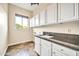 Laundry room featuring a sink with granite countertops and white cabinets at 10059 W Villa Lindo Dr, Peoria, AZ 85383