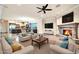 Bright, open living room featuring a stone fireplace, and a view of the kitchen and dining area at 10059 W Villa Lindo Dr, Peoria, AZ 85383