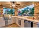Fully equipped outdoor kitchen and grill with a view of the pool and waterfall at 10059 W Villa Lindo Dr, Peoria, AZ 85383