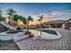 Resort-style pool with rock waterfall and slide, surrounded by lush landscaping and paver patio at 10059 W Villa Lindo Dr, Peoria, AZ 85383