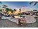 Inviting backyard pool with slide, rock waterfall, and desert landscaping; perfect for outdoor relaxation and entertainment at 10059 W Villa Lindo Dr, Peoria, AZ 85383