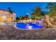 Private backyard oasis with a stunning pool featuring a rock waterfall and lush landscaping at 10059 W Villa Lindo Dr, Peoria, AZ 85383