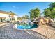 An in-ground pool features a stone grotto with slide and staircase at 10059 W Villa Lindo Dr, Peoria, AZ 85383