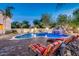 Sparkling pool with a rock waterfall feature surrounded by lush landscaping at 10059 W Villa Lindo Dr, Peoria, AZ 85383