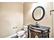 Powder room with decorative vanity and dark granite sink at 10059 W Villa Lindo Dr, Peoria, AZ 85383
