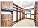 Spacious walk-in closet features custom wood shelving, drawers, and hanging rods and a chandelier at 10059 W Villa Lindo Dr, Peoria, AZ 85383