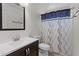 Modern bathroom with dark vanity and sink and shower with curtain at 10817 W Wilshire Dr, Avondale, AZ 85392