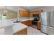 Bright kitchen with stainless steel appliances, wood cabinets, and a breakfast bar at 10817 W Wilshire Dr, Avondale, AZ 85392