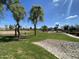 Open grassy park featuring paved walkway, mature trees, and lush green grass under a blue sky at 10817 W Wilshire Dr, Avondale, AZ 85392
