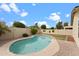 A backyard view of the pool with grass and a beige brick fence and blue sky at 10817 W Wilshire Dr, Avondale, AZ 85392