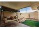 Cozy covered patio with pavers, rock landscaping, and a comfortable swing at 11122 W Desert Butte Dr, Sun City, AZ 85351