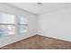 Empty bedroom featuring carpet, two windows, and white walls at 148 E Douglas Ave, Coolidge, AZ 85128