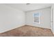 Neutral bedroom featuring carpet, a window, and white walls at 148 E Douglas Ave, Coolidge, AZ 85128