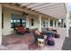 The covered back patio features an outdoor seating area with comfortable wicker furniture and a decorative fire pit at 15948 W Sheila Ln, Goodyear, AZ 85395