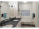 Bright bathroom with granite countertop, dual sinks, built-in cabinet, and soaking tub under a window at 15948 W Sheila Ln, Goodyear, AZ 85395