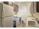 Laundry room with white appliances, cabinets, countertop, and sink at 15948 W Sheila Ln, Goodyear, AZ 85395