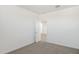A white-walled bedroom with neutral carpet and a walk-in closet at 17642 W Sanna St, Waddell, AZ 85355