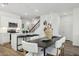 Chic dining area with modern table and chairs, flowing into the kitchen and featuring a decorative staircase at 17642 W Sanna St, Waddell, AZ 85355