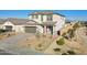 Striking two-story home showcasing a well-maintained front yard with decorative rock and an eye-catching red front door at 17642 W Sanna St, Waddell, AZ 85355