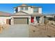 Charming two-story home featuring a red door, neutral color scheme, and low maintenance front yard landscaping at 17642 W Sanna St, Waddell, AZ 85355