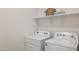 Functional laundry room features modern appliances and shelf storage with towels and a basket at 17642 W Sanna St, Waddell, AZ 85355