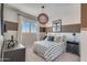 Stylish bedroom with a striped bedspread, unique hanging lamp, and natural light streaming through plantation shutters at 17807 W Mission Ln, Waddell, AZ 85355