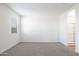 Light-filled bedroom featuring neutral carpet, one window, and light neutral paint at 17825 W Mission Ln, Waddell, AZ 85355