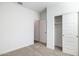 Clean bedroom with carpet, and a sliding-door closet; open doors to the hallway and another closet at 17825 W Mission Ln, Waddell, AZ 85355