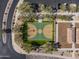 An aerial showcases a basketball court and playground situated within the community, surrounded by trees and green space at 18491 N 98Th Way, Scottsdale, AZ 85255