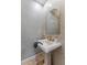 Chic powder room with decorative tile wall, pedestal sink, and gold fixtures at 18491 N 98Th Way, Scottsdale, AZ 85255
