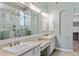 Bathroom featuring double sinks, quartz countertops, and a luxurious glass walk-in shower at 18491 N 98Th Way, Scottsdale, AZ 85255