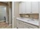 Bright laundry room featuring white cabinetry, countertop space and a convenient sink at 18491 N 98Th Way, Scottsdale, AZ 85255
