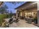 Inviting covered patio with lounge chairs, dining set, and outdoor kitchen; seamless indoor-outdoor living at 18491 N 98Th Way, Scottsdale, AZ 85255