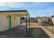 Backyard showing a covered parking space with access to the home through a charming turquoise door at 1851 E Pleasant Ln, Phoenix, AZ 85042