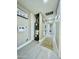 Hallway with light grey floors leading to bathroom; laundry themed decor at 1851 E Pleasant Ln, Phoenix, AZ 85042