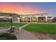 Spacious backyard with covered patio, outdoor seating, and lush green lawn at 19717 E Country Meadows Dr, Queen Creek, AZ 85142