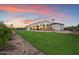Stunning backyard view with a large green lawn, covered patio, and well-maintained landscaping at 19717 E Country Meadows Dr, Queen Creek, AZ 85142