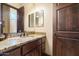 Elegant bathroom with dual mirrors, granite counters and wooden door offering a spa-like retreat at 19717 E Country Meadows Dr, Queen Creek, AZ 85142