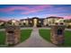 Elegant single-story home featuring a circular driveway and striking entry pillars at dusk at 19717 E Country Meadows Dr, Queen Creek, AZ 85142