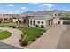 Stunning home featuring lush landscaping, a circular driveway, and a three-car garage at 19717 E Country Meadows Dr, Queen Creek, AZ 85142